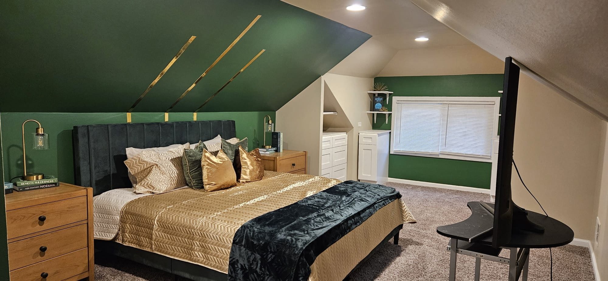 Finished primary bedroom with green accent wall and styled furnishings